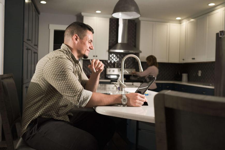 adult learner at kitchen island on laptop