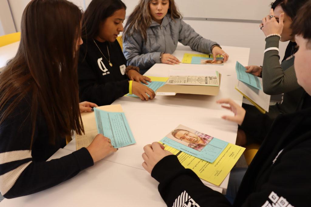 students working on a cold case sitting at a table with papers